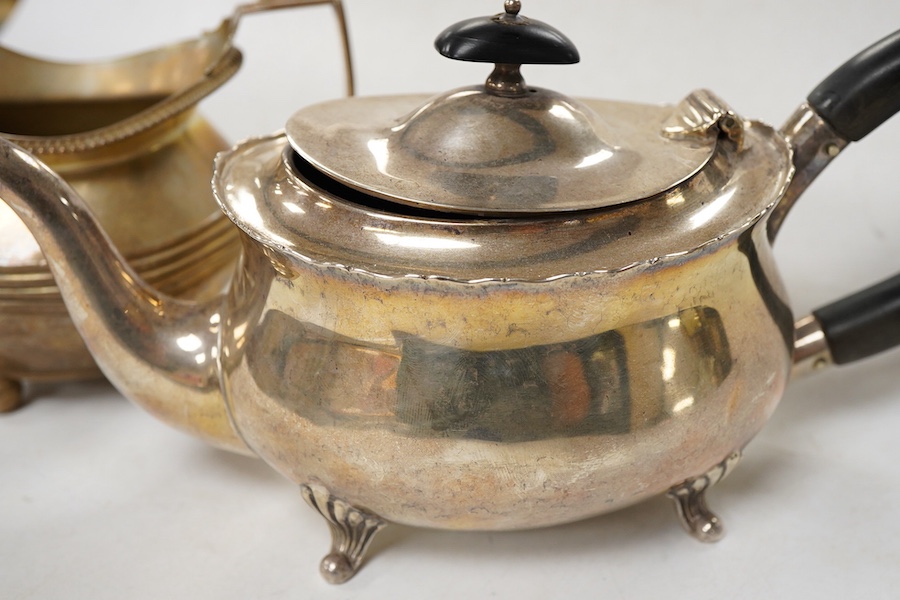 A late Victorian silver oval teapot, William Hutton & Sons, London, 1899, together with a George III silver cream jug, London, 1811, gross weight 15.4oz.